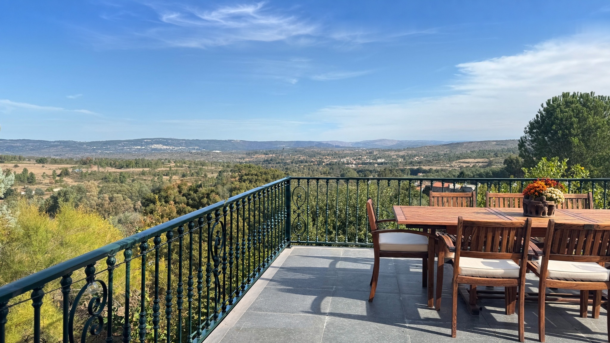 Dining on the deck overlooking the valley, with restored planting and chair cushions